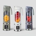 Three portable blenders with fruit inside on a colorful background with fruits and ice cubes.